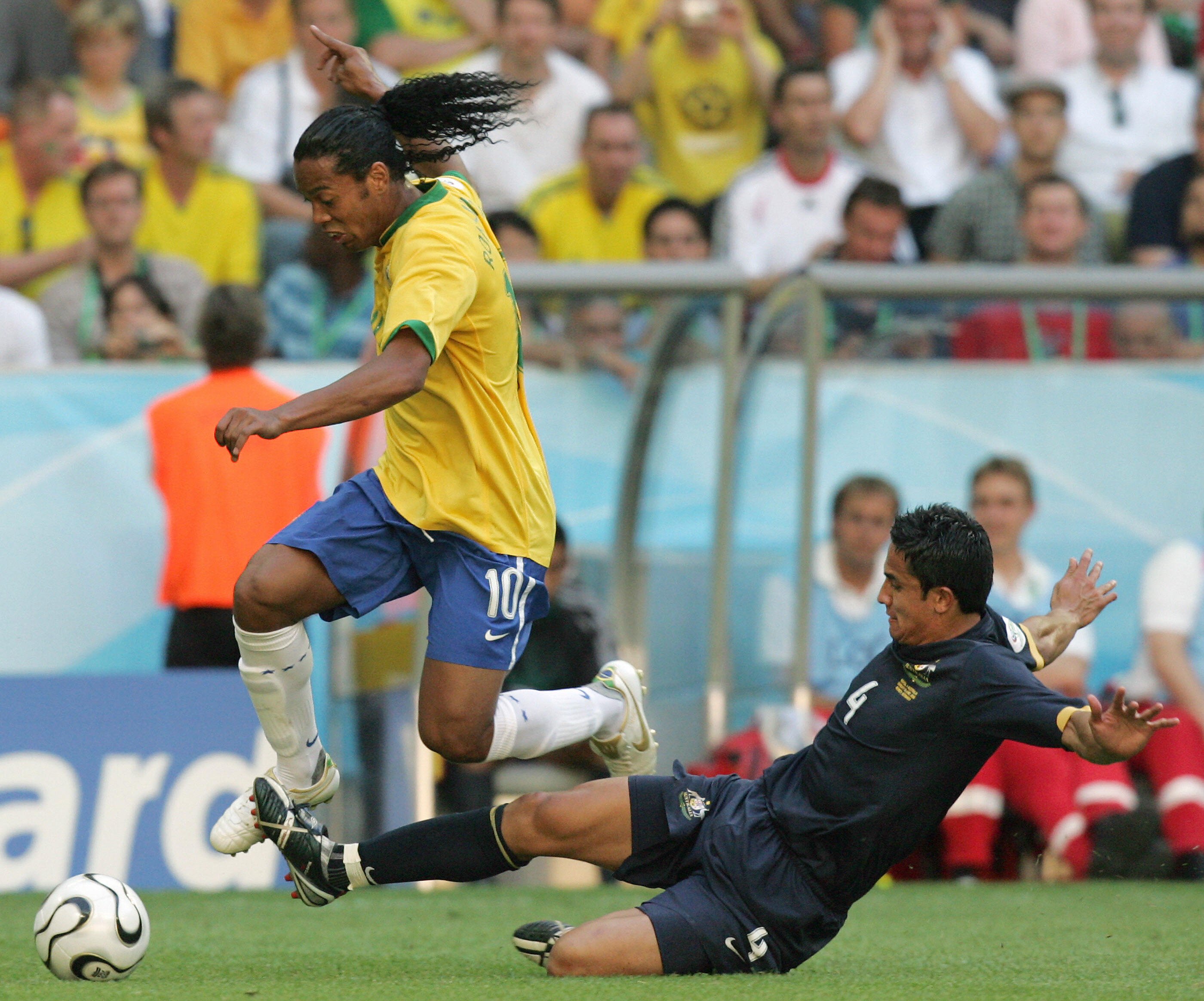 Munich, GERMANY:  Brazilian midfielder Ronaldinho (L) is tackled by Australian midfielder Tim Cahill (R) in their opening round Group F World Cup football match at Munich's World Cup Stadium, 18 June 2006.  The score was 0-0 at half-time.          AFP PHOTO / ROBERTO SCHMIDT  (Photo credit should read ROBERTO SCHMIDT/AFP via Getty Images)